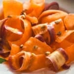 Close-up of carrot ribbons tossed in oxymelo honey-vinegar dressing with almond skordalia.