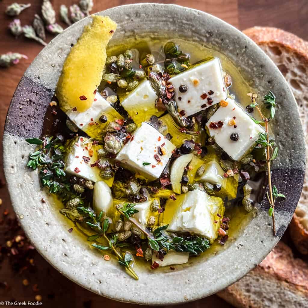 Greek marinated feta cheese in olive oil with herbs and garlic cloves