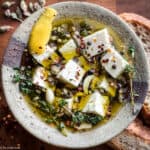 Greek marinated feta cheese in olive oil with herbs and garlic cloves