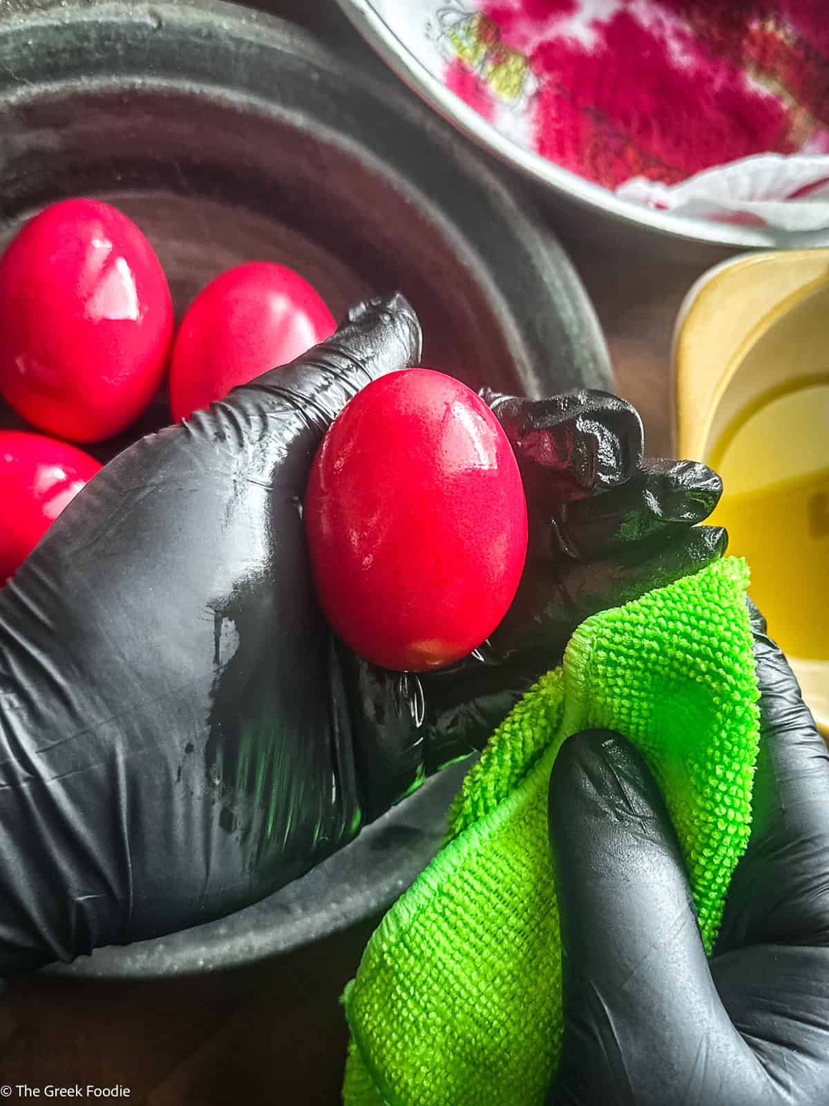Polishing Greek Easter red eggs with gloves