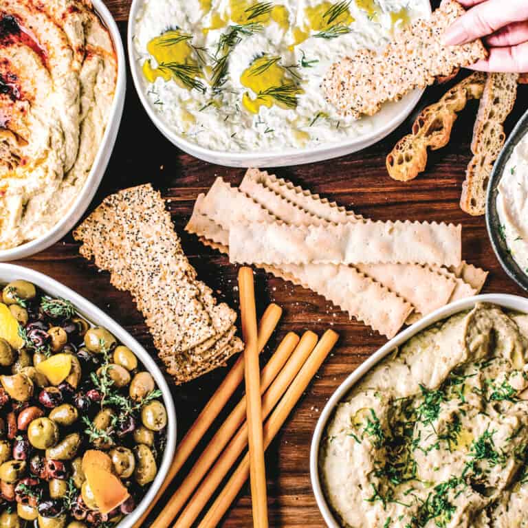 A generous Greek mezze table with dips, olives, and crackers — the perfect Easter spread