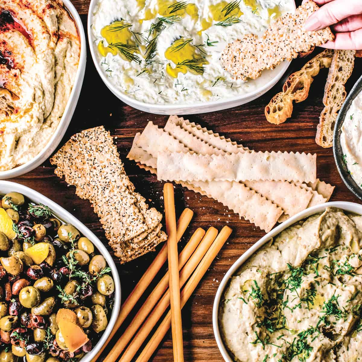 A generous Greek mezze table with dips, olives, and crackers — the perfect Easter spread