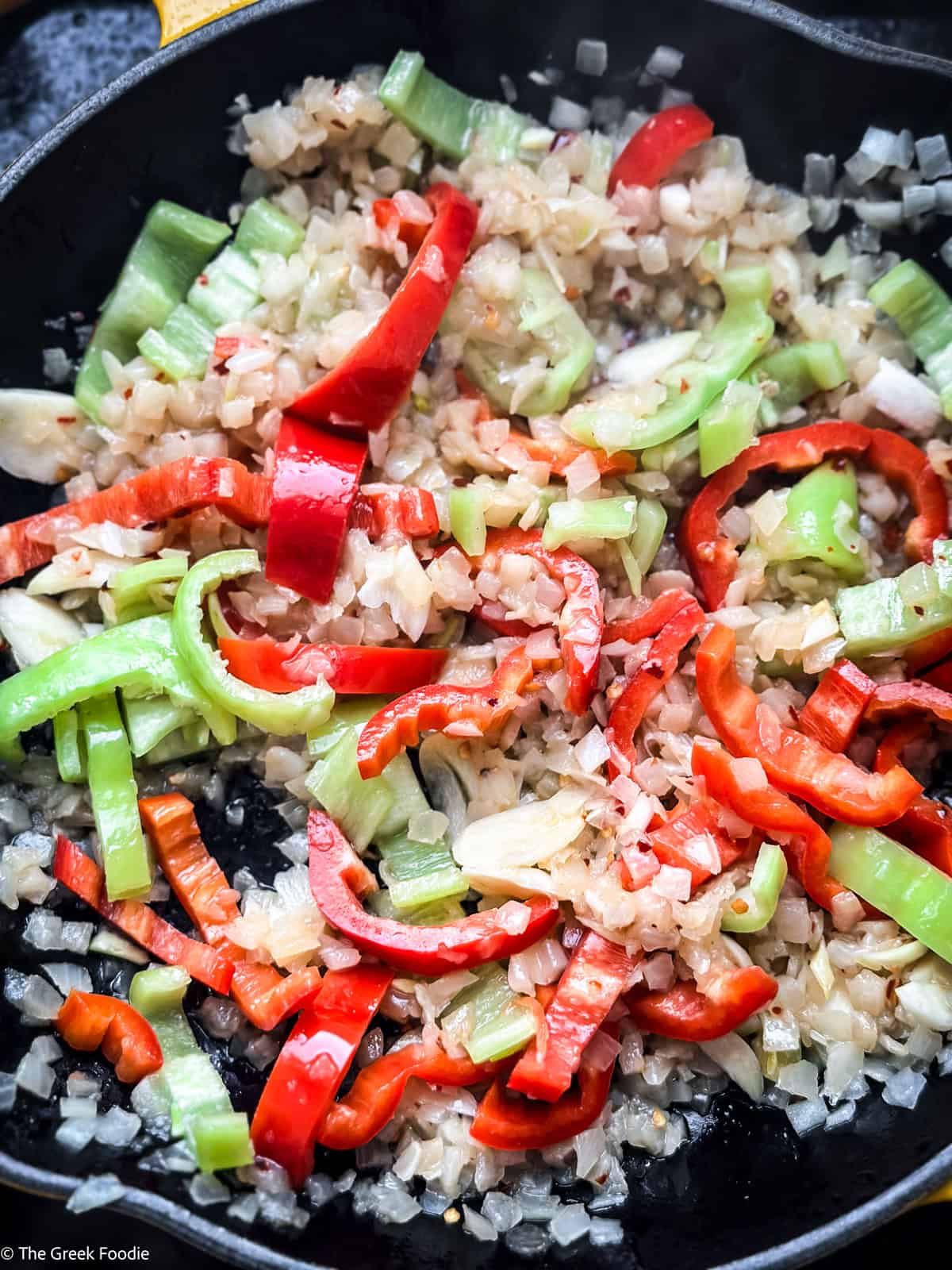 bekri-meze-peppers.jpg Green, red and Florina peppers added to onions and garlic in a cast iron skillet for bekri meze