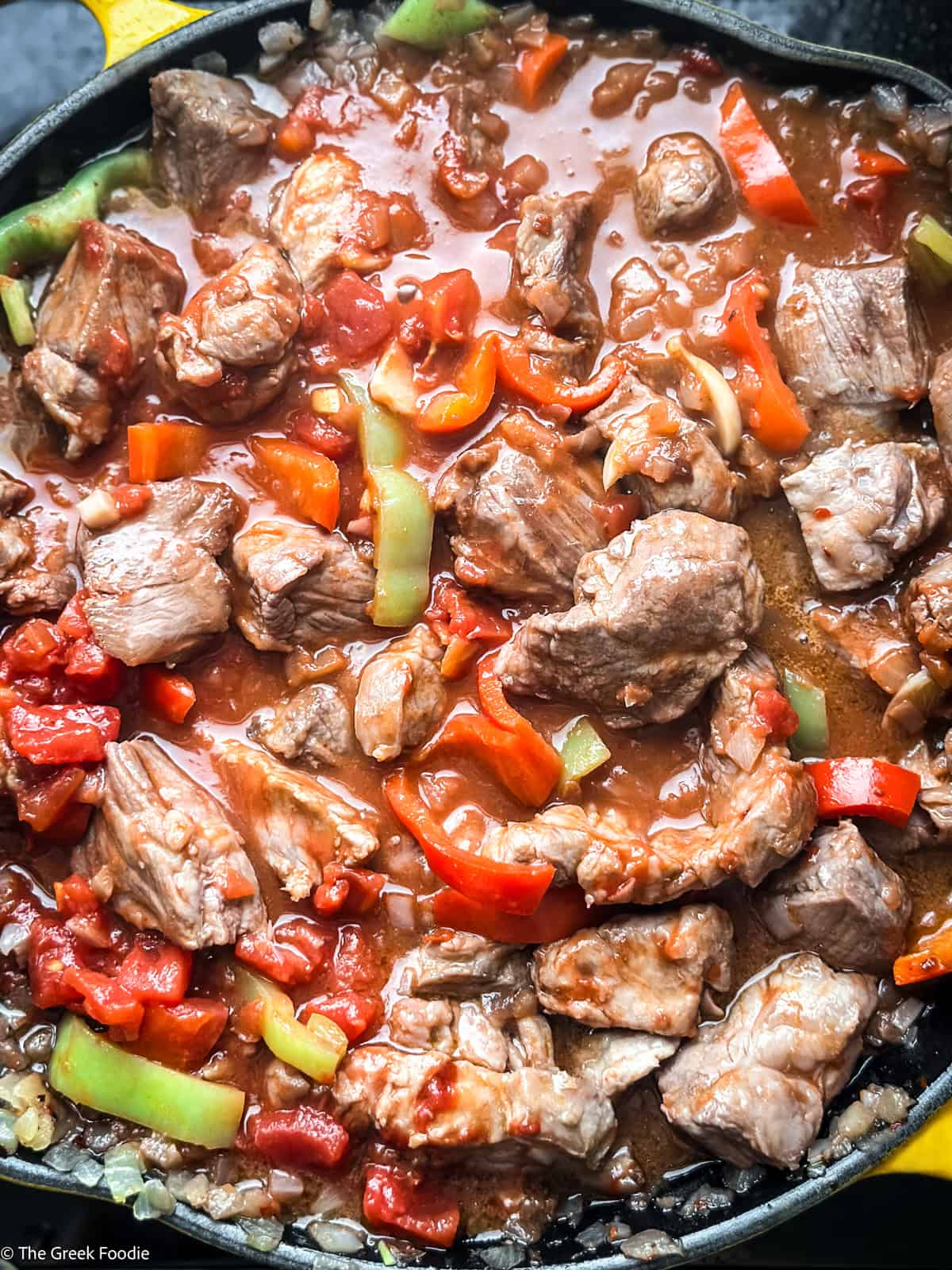 bekri-meze-tomatoes.jpg Canned tomatoes added to bekri meze — pork neck with three peppers beginning to braise in tomato sauce