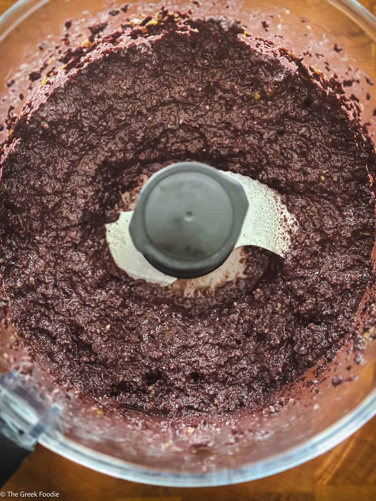 Smooth kalamata olive tapenade blended in a food processor bowl