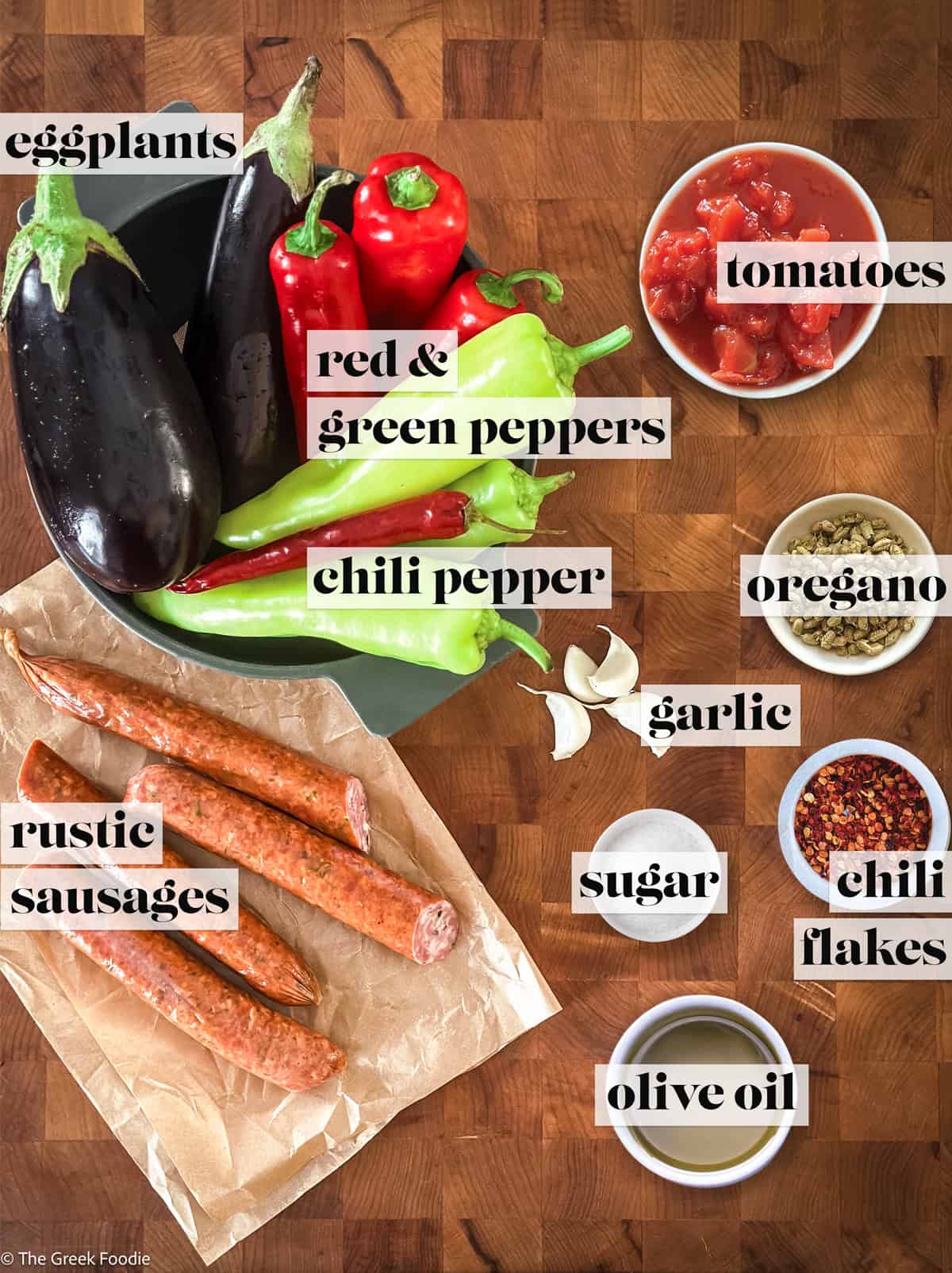 Ingredients for authentic Greek spetzofai — loukaniko sausage, Florina peppers, eggplant, tomatoes, garlic, chili, and oregano