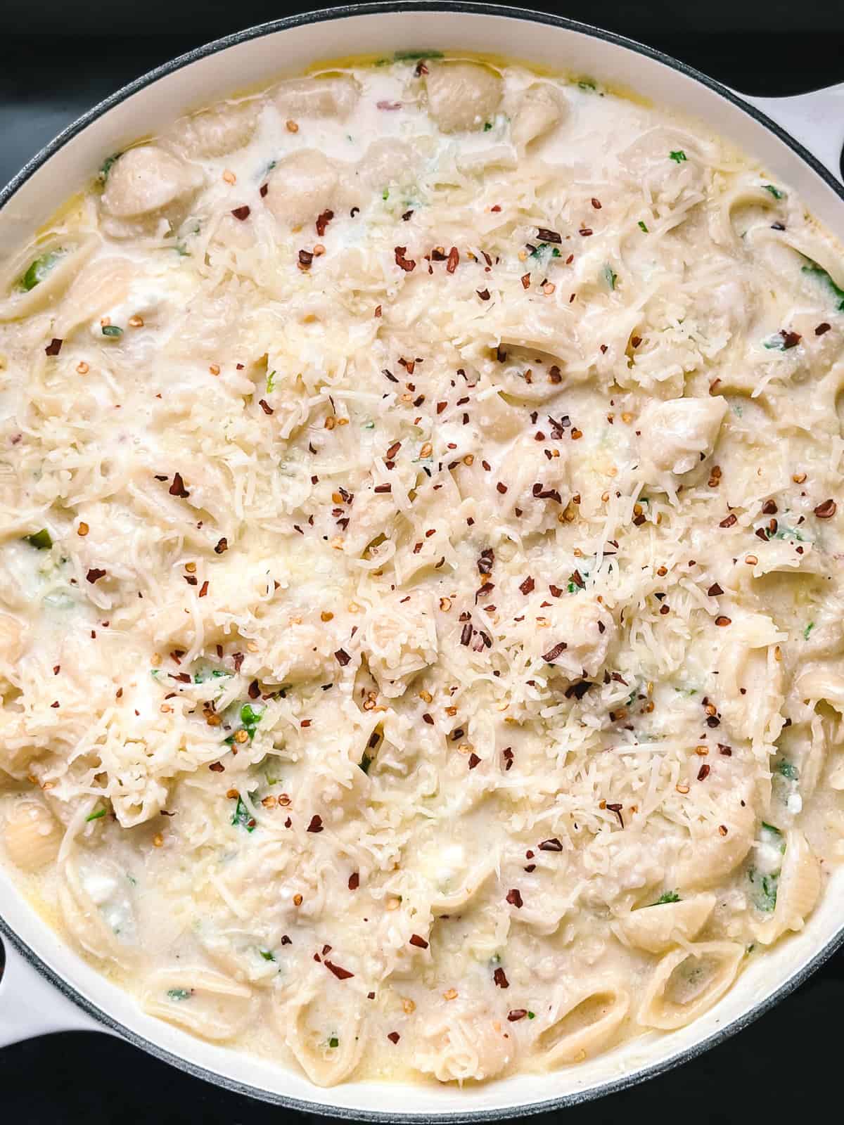 Shell pasta coated in the feta and graviera sauce, topped with grated graviera and ready to go into the oven.