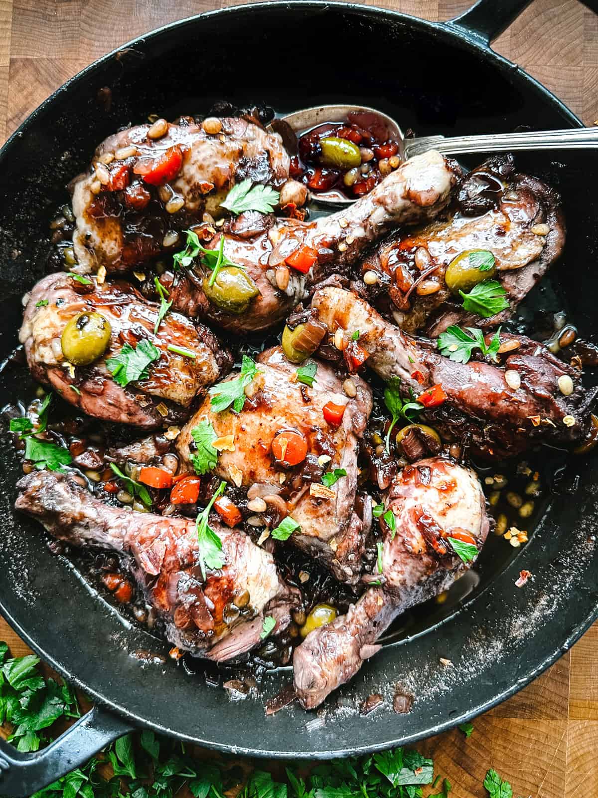 Sicilian chicken recipe simmered in red wine reduction with olives, almonds, and fresh parsley