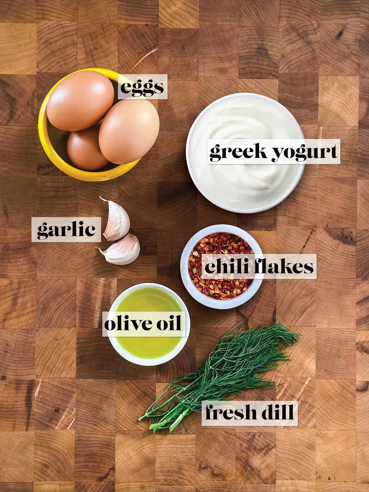 Ingredients for Greek yogurt eggs: eggs, strained Greek yogurt, garlic, chili flakes, olive oil, and fresh dill