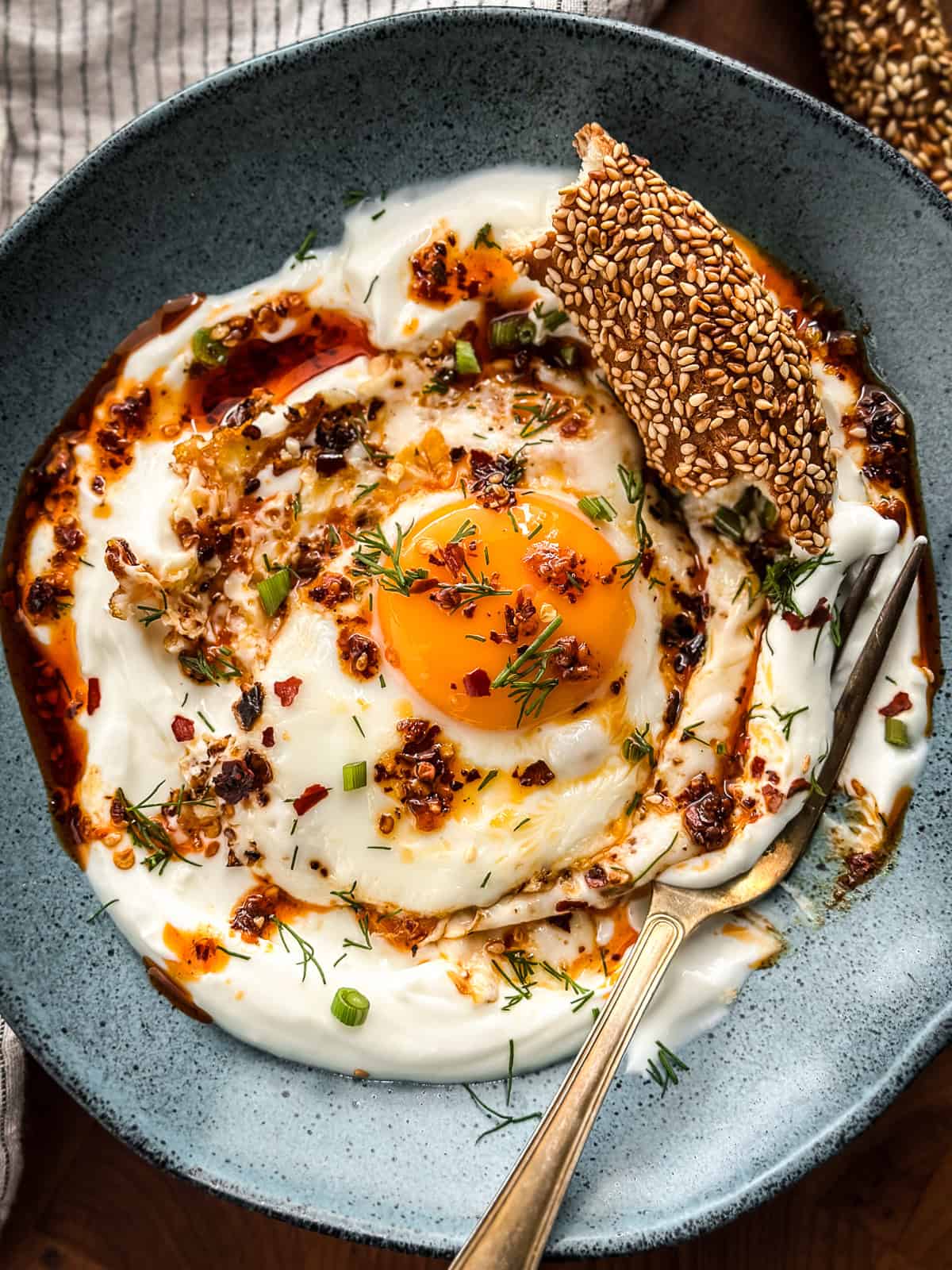 Greek yogurt eggs breakfast plate with fried egg, garlic yogurt, and toasted sesame bread