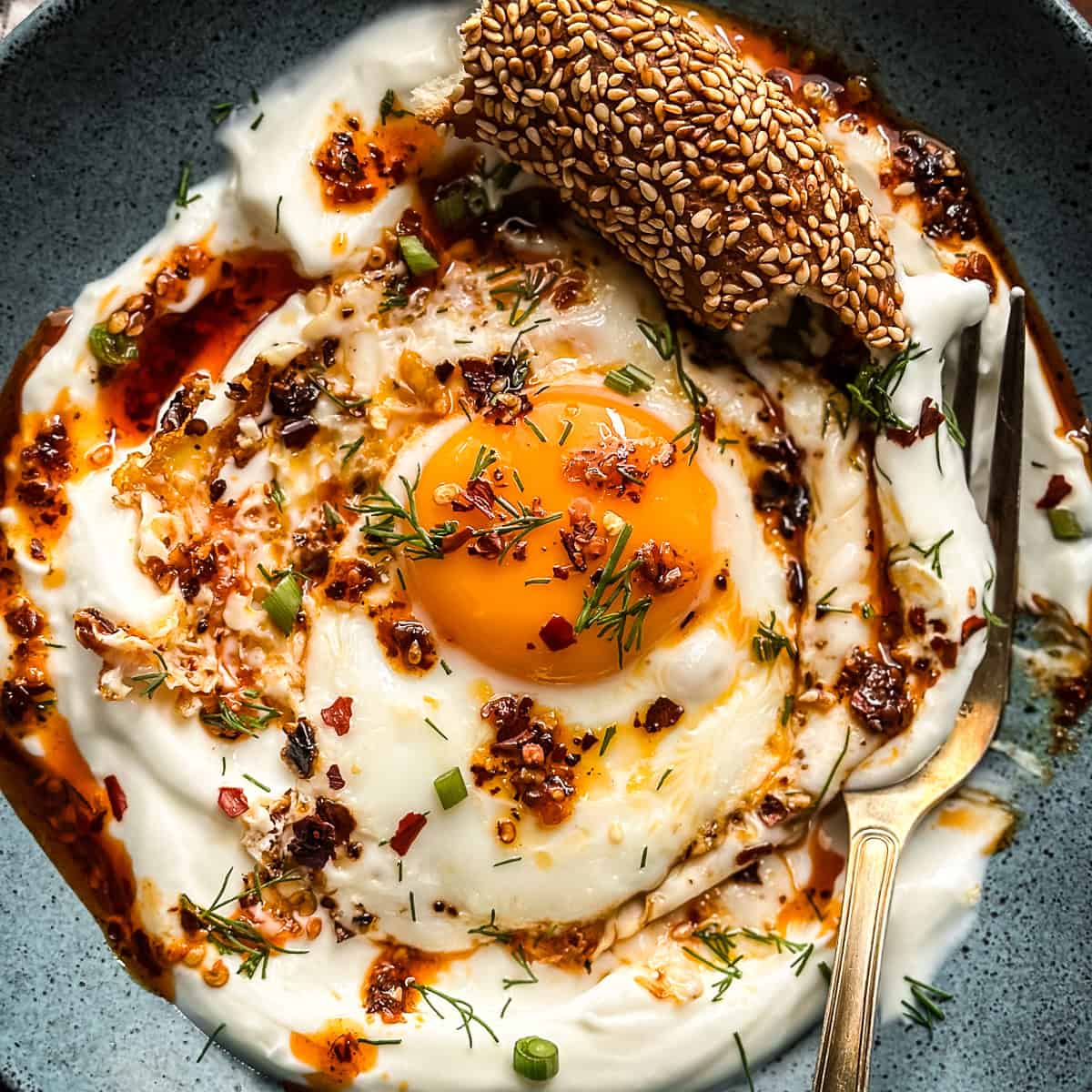 Runny egg yolk over strained Greek yogurt, finished with chili flakes and fresh dill