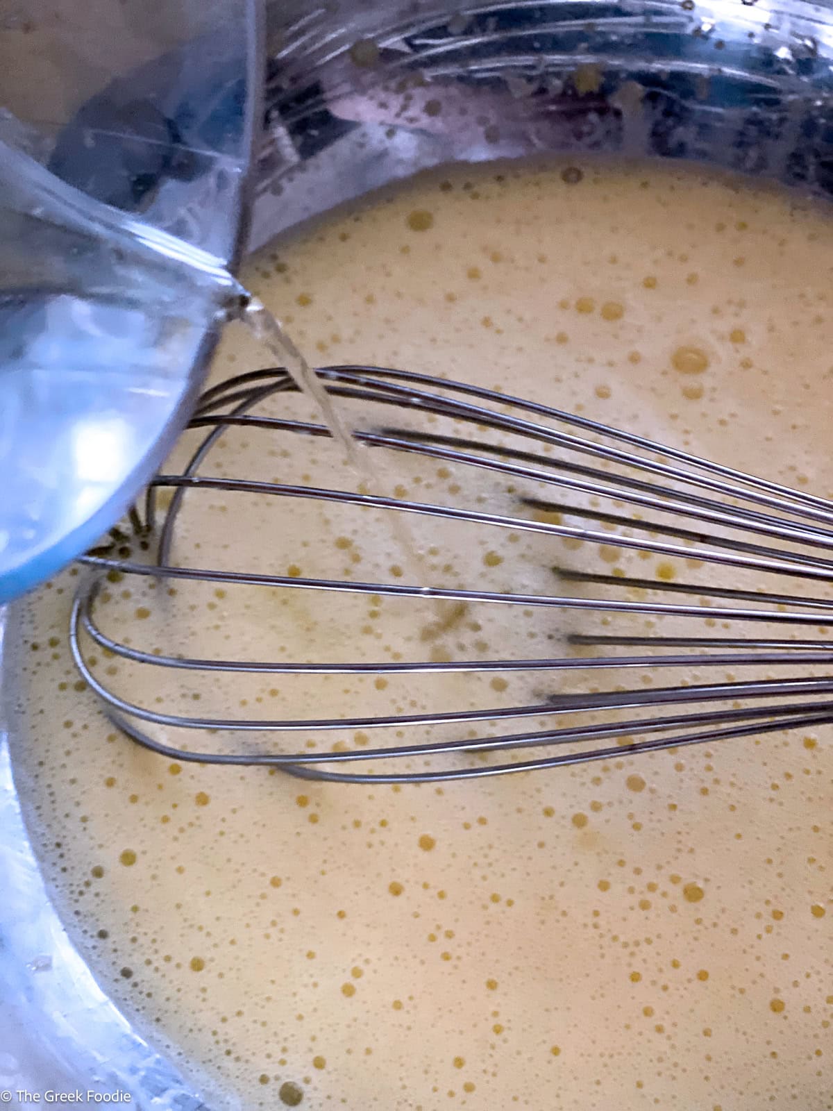 Hot broth drizzled slowly into the egg and lemon mixture while whisking, to temper it