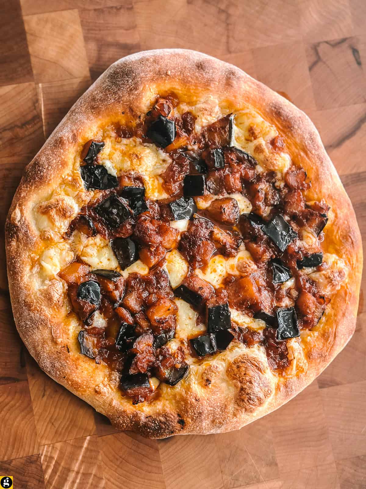 Baked eggplant pizza with melted mozzarella and a blistered crust, before the burrata and toppings.