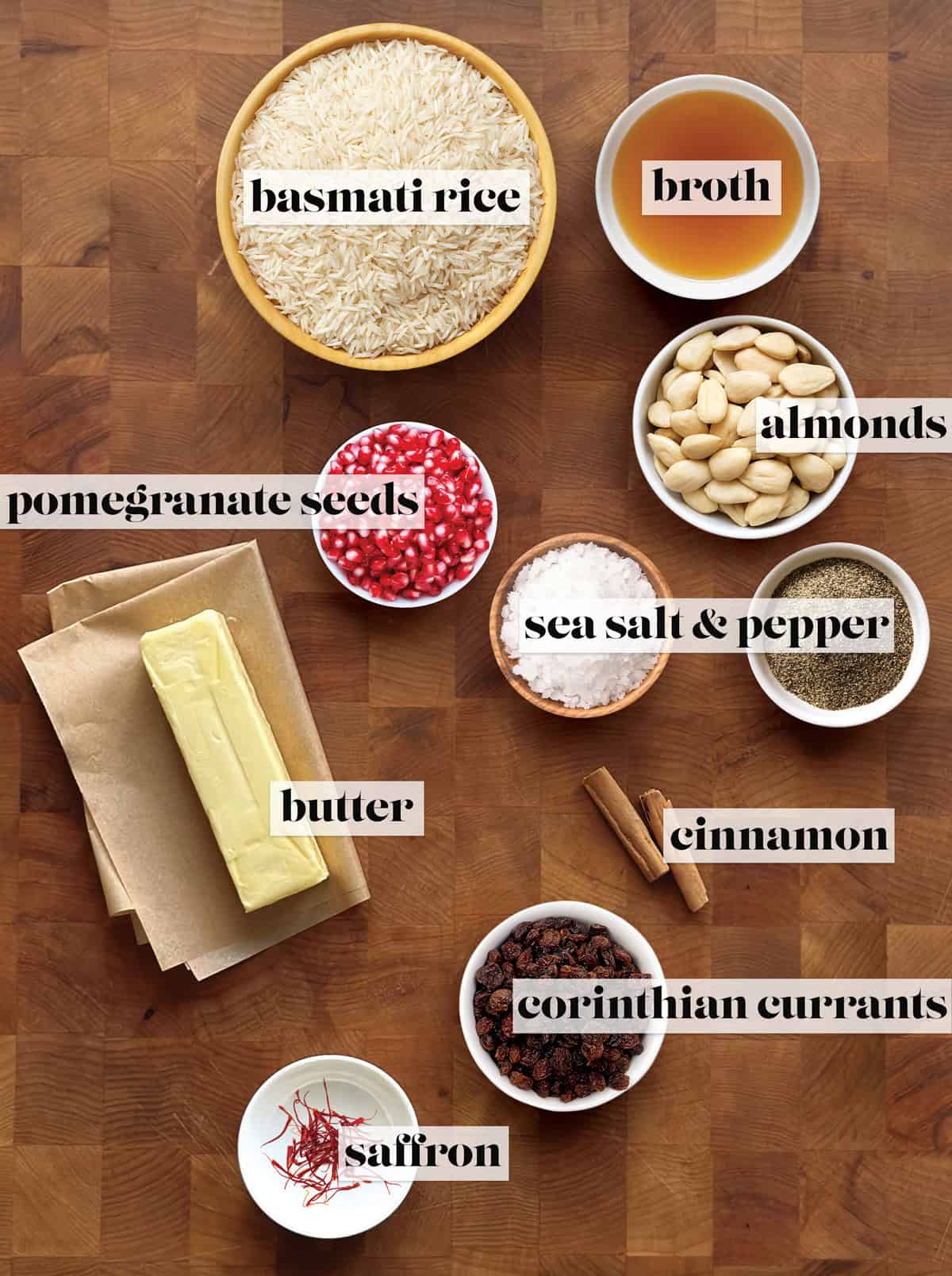 Ingredients for Greek saffron rice pilaf: basmati rice, chicken broth, butter, saffron, cinnamon sticks, Corinthian currants, blanched almonds, pomegranate seeds, sea salt and pepper.