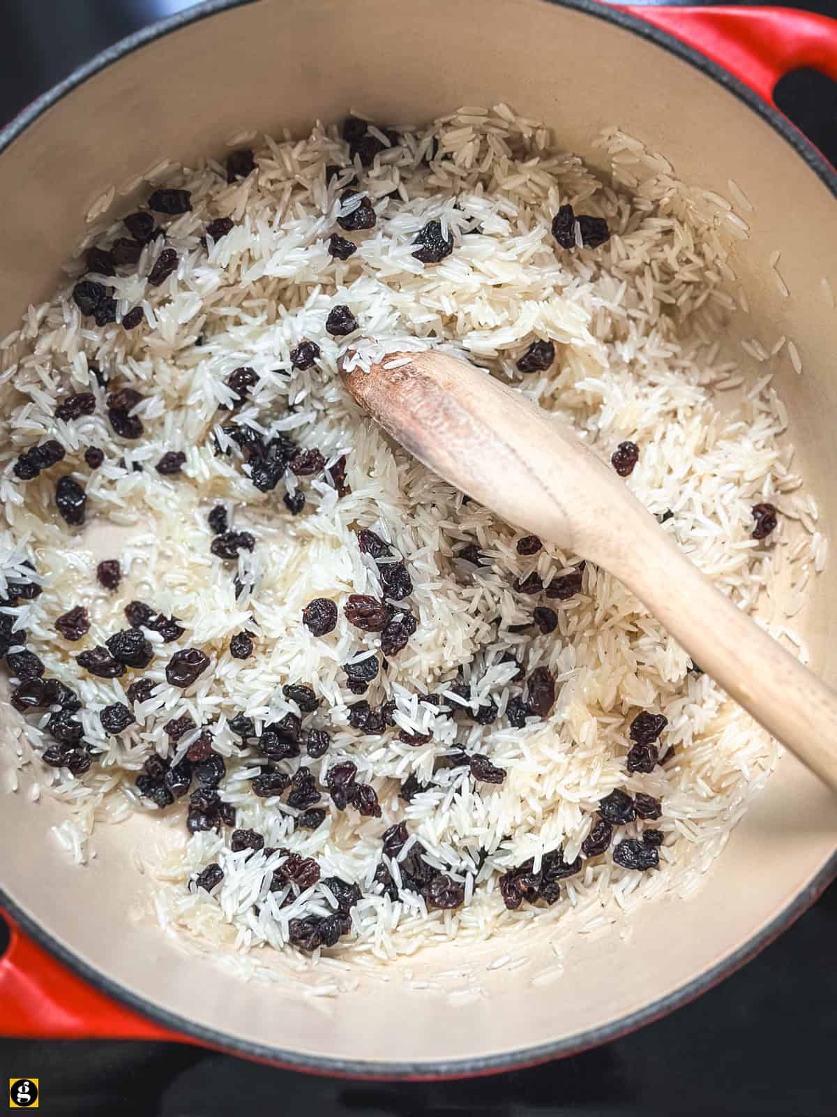 Basmati rice and Corinthian currants stirred into melted butter with a wooden spoon.