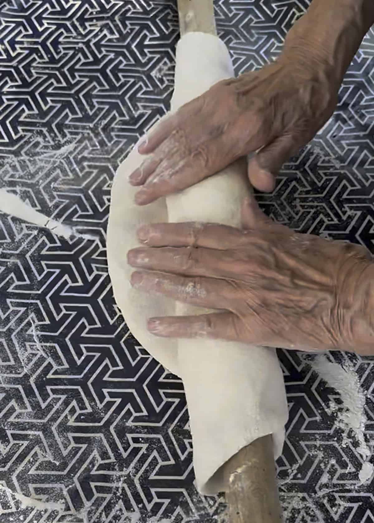 Phyllo dough rolled around the pin and spread thinner with each pass.