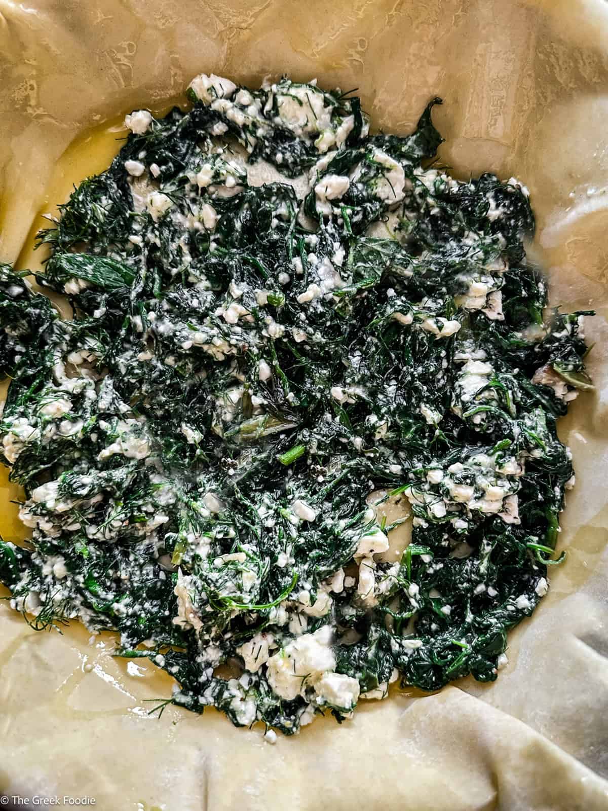 Another layer of spinach and feta filling spread over the wrinkled phyllo.