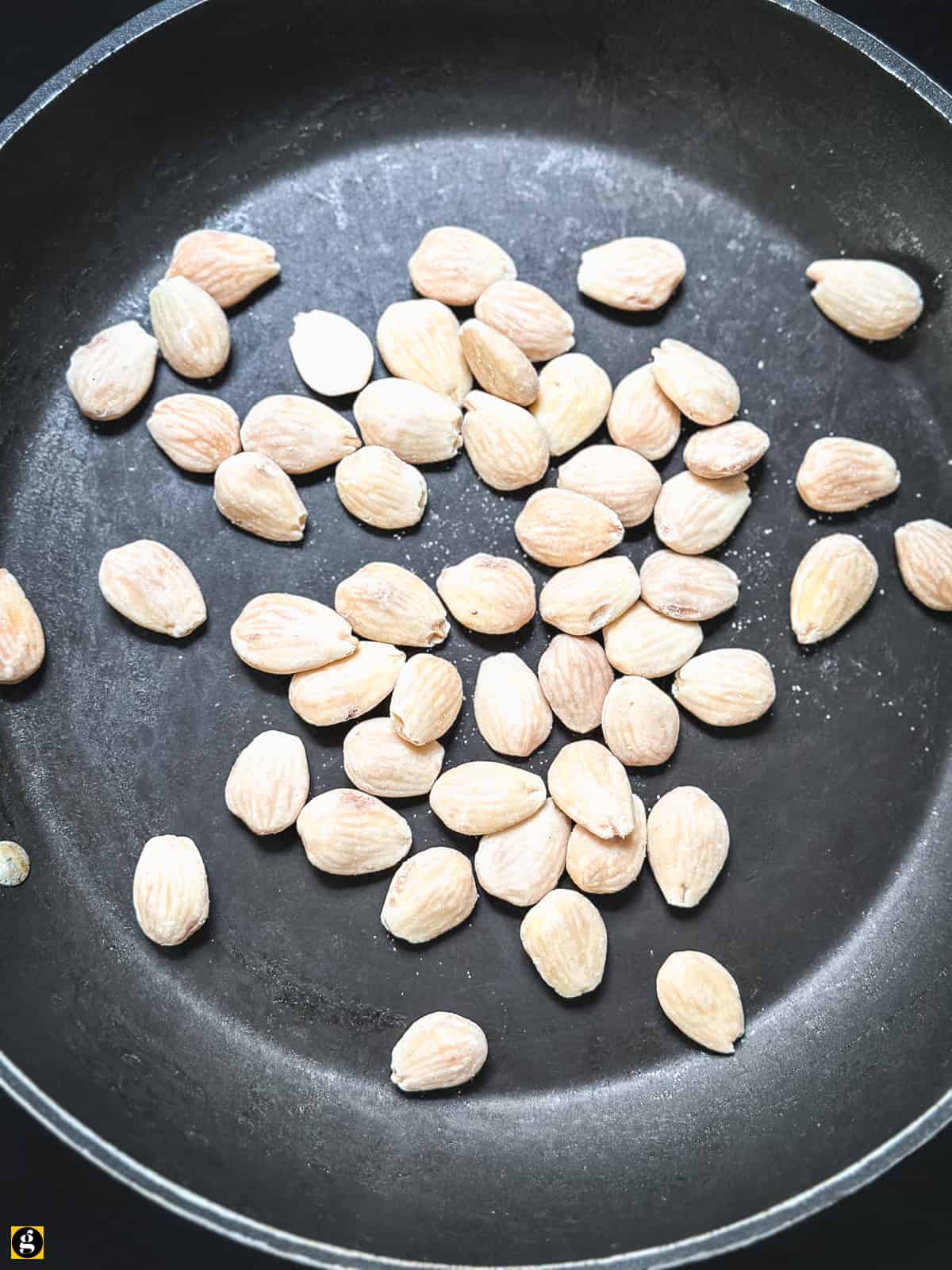 Whole almonds toasting in a pot for Greek halva
