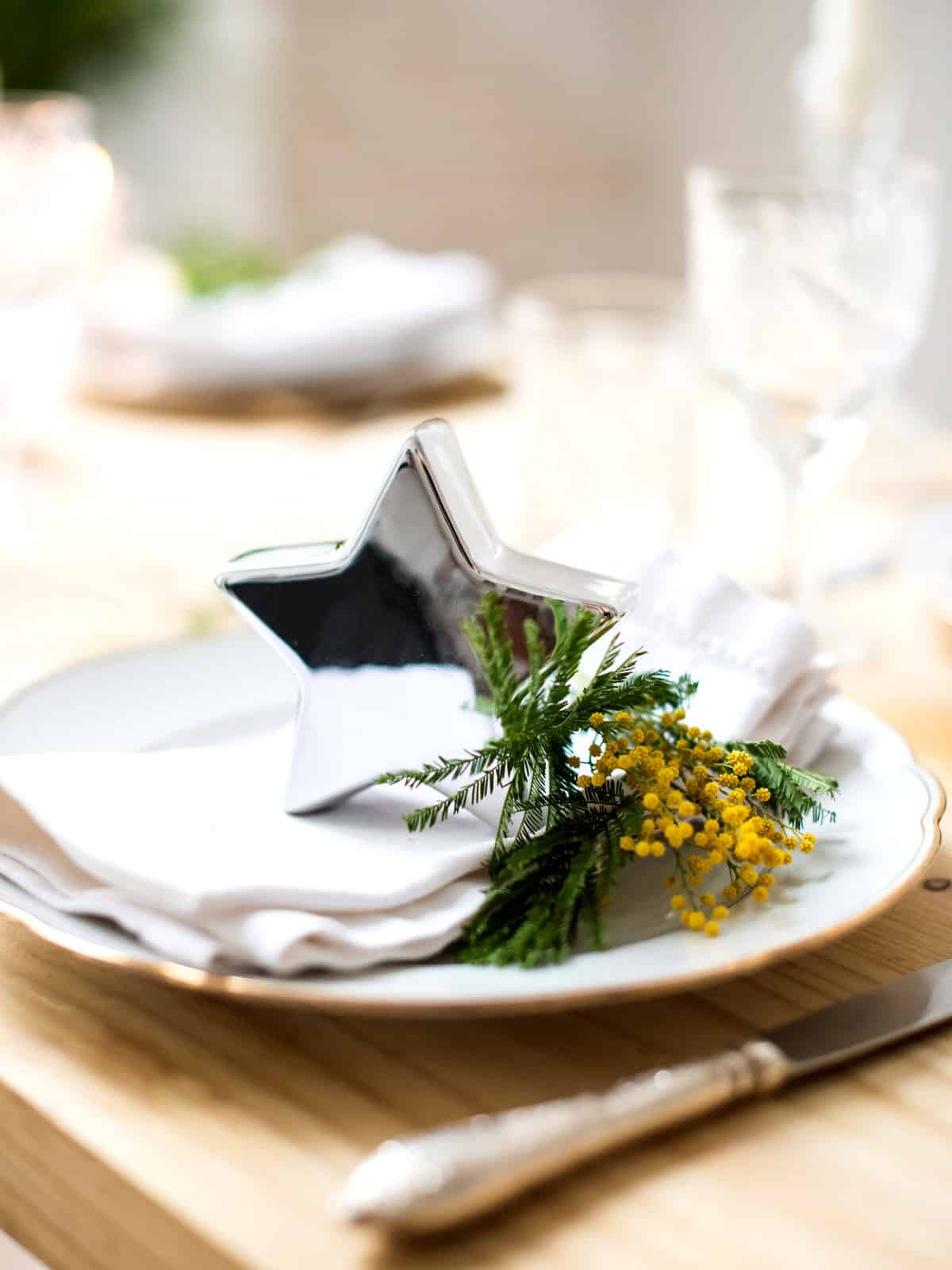 A silver star on a plate with chrysanthemum flowers as  Christmas decor for Greek Christmas celebrations.