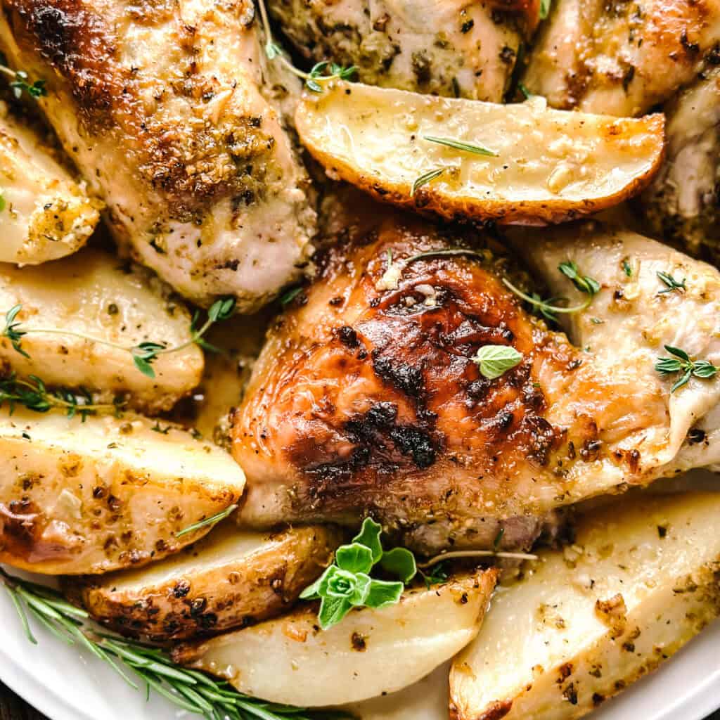 Greek Mediterranean diet dinner recipe with chicken thighs, potatoes, olives and feta roasted together on one pan.