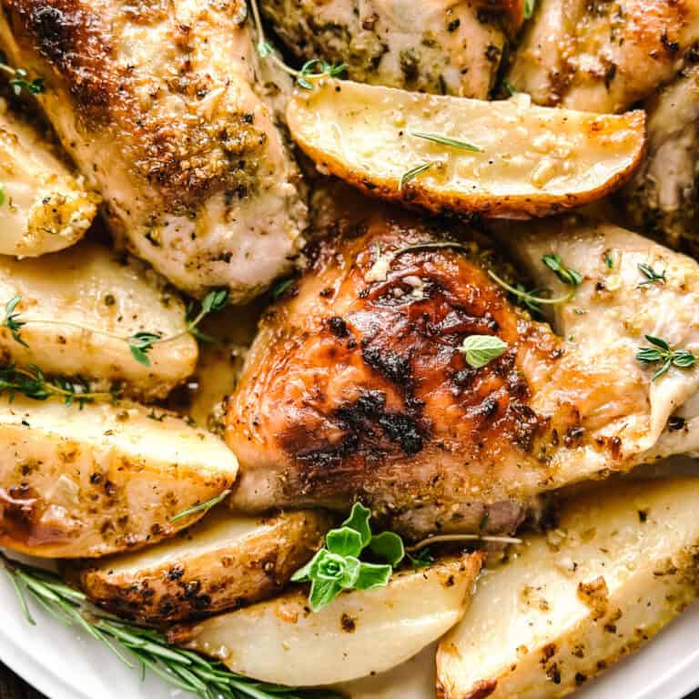 Greek Mediterranean diet dinner recipe with chicken thighs, potatoes, olives and feta roasted together on one pan.