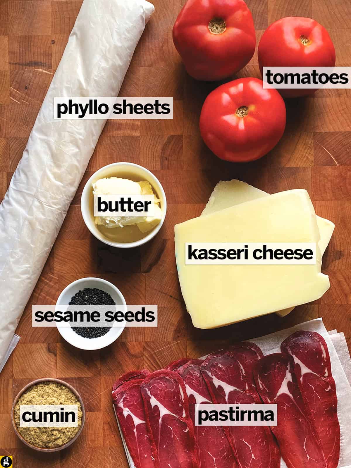 Ingredients for kasseri cheese pie: phyllo, kasseri cheese, pastirma, tomatoes, butter, cumin and black sesame seeds