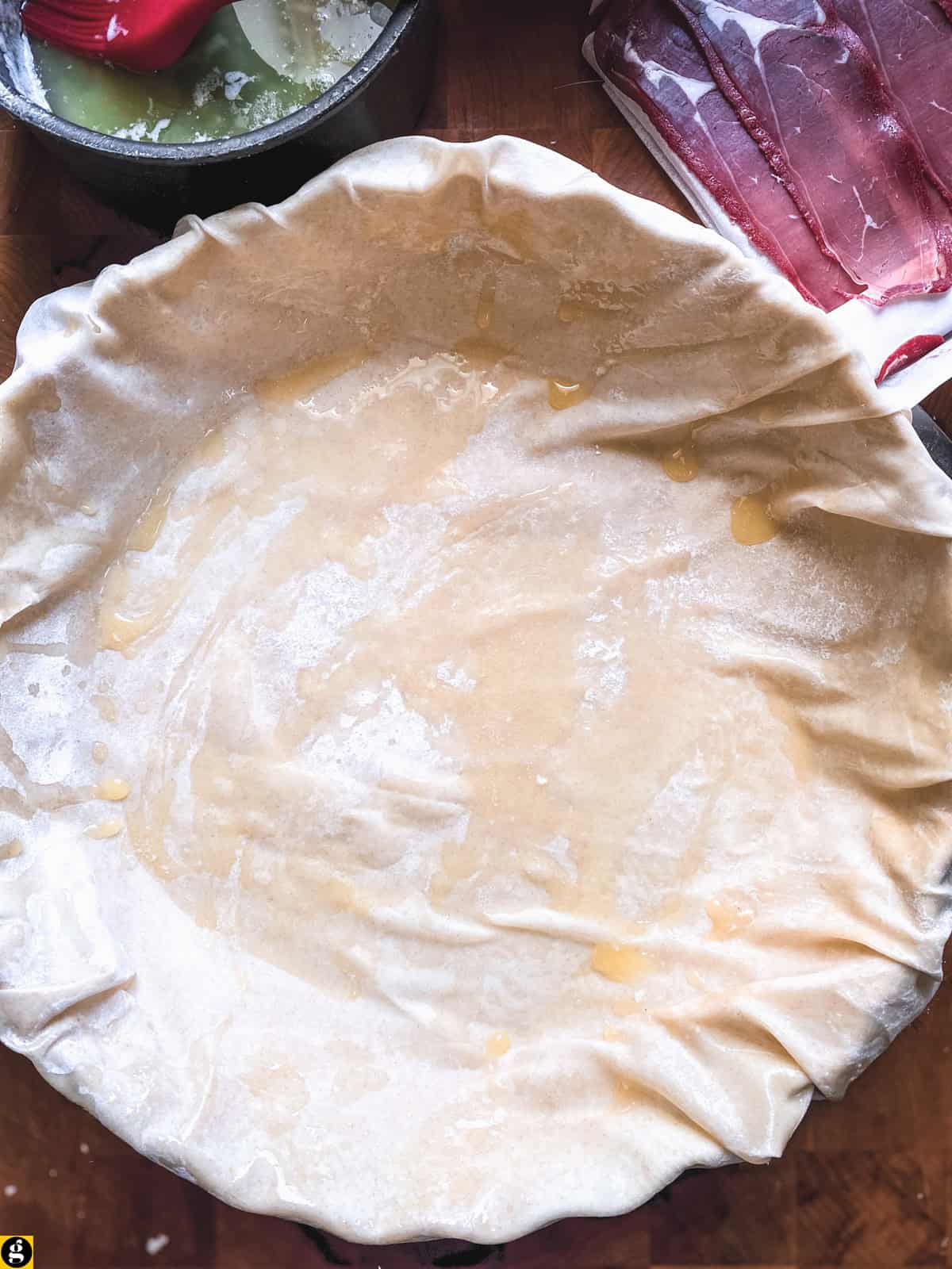 Buttered phyllo sheets lining a fluted tart pan