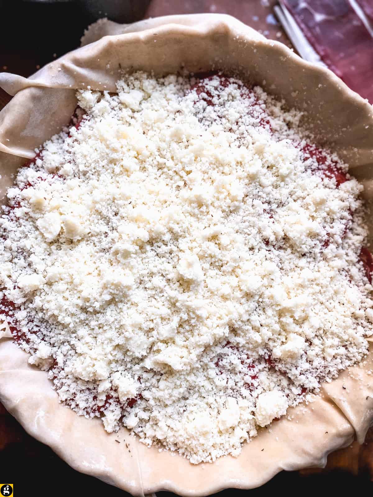 Grated kasseri cheese spread over the tomatoes in a phyllo pie